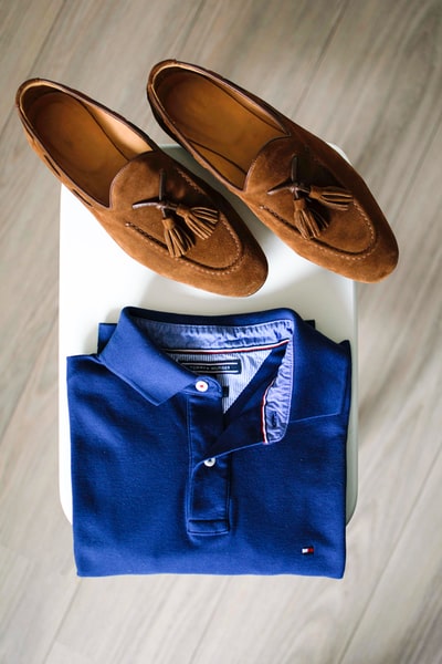 一双棕色休闲鞋和一件蓝色马球衫